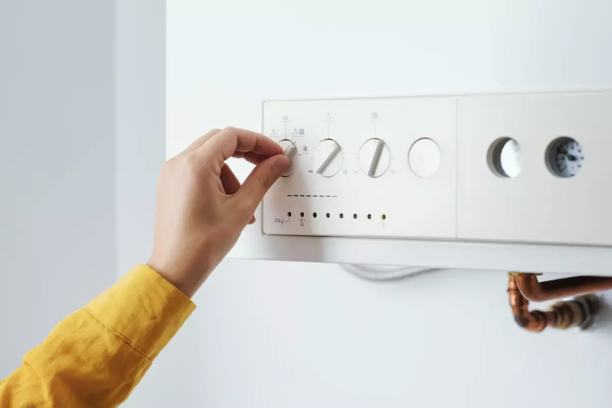 Person adjusting a thermostat to resolve issues with the AC