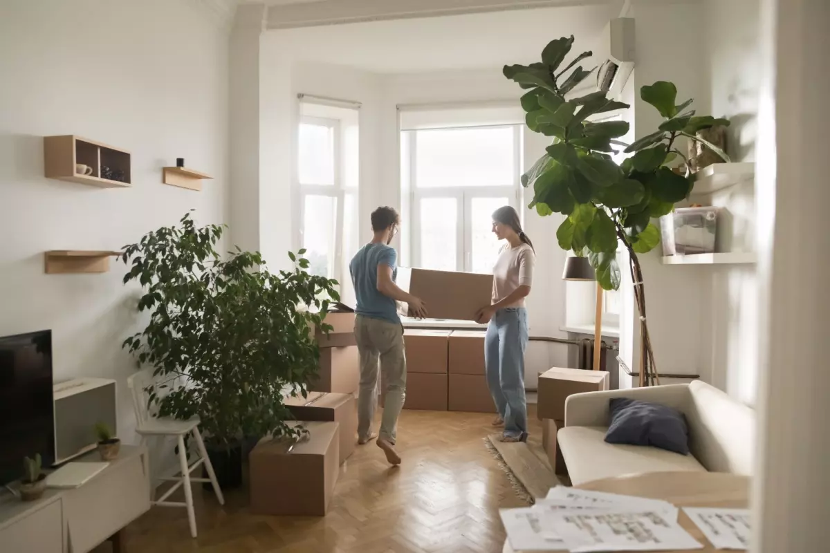 a couple lifting a box inside their homw