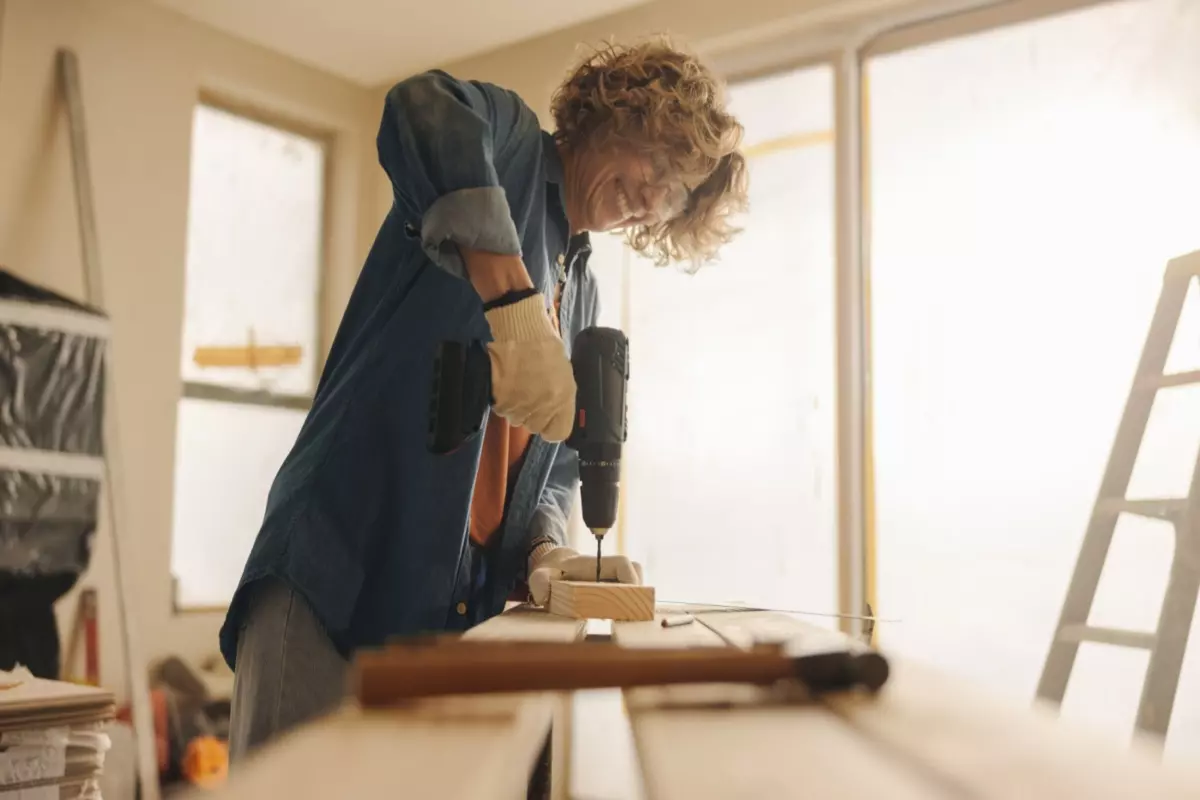 person drilling into a wooden piece