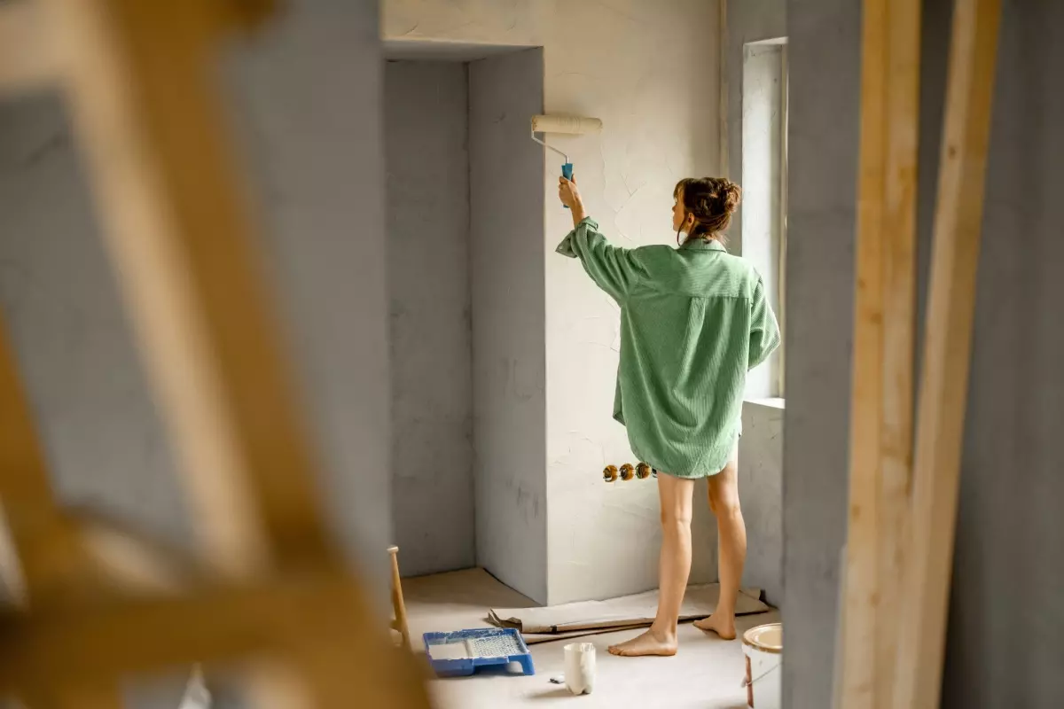 a woman painting her wall