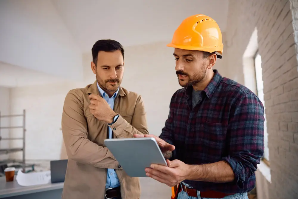Homeowner and construction professional reviewing renovation information on a tablet