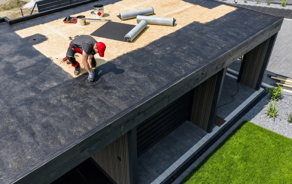 Contractor installing an EPDM membrane on a residential flat roof