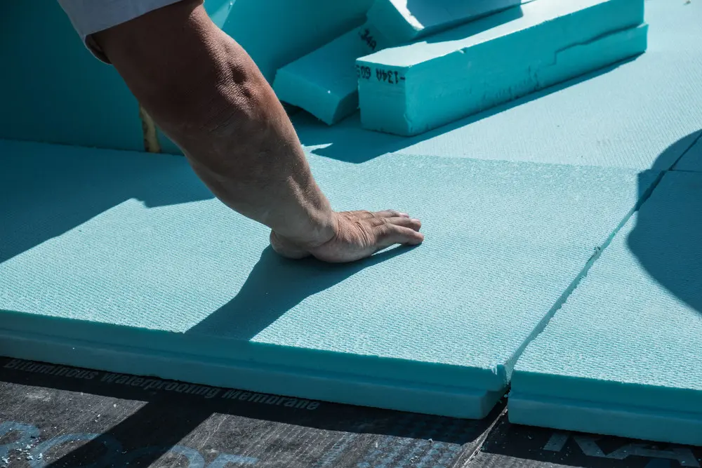 Rigid insulation boards being installed as part of a flat-roof system