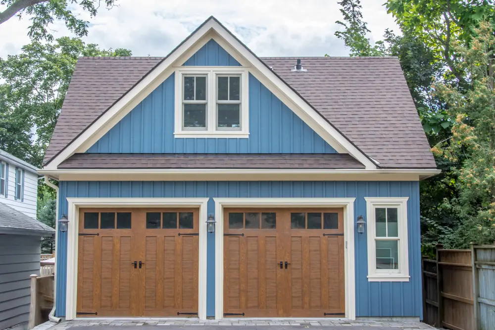 Blue detached two-car garage with a gray asphalt-shingle roof