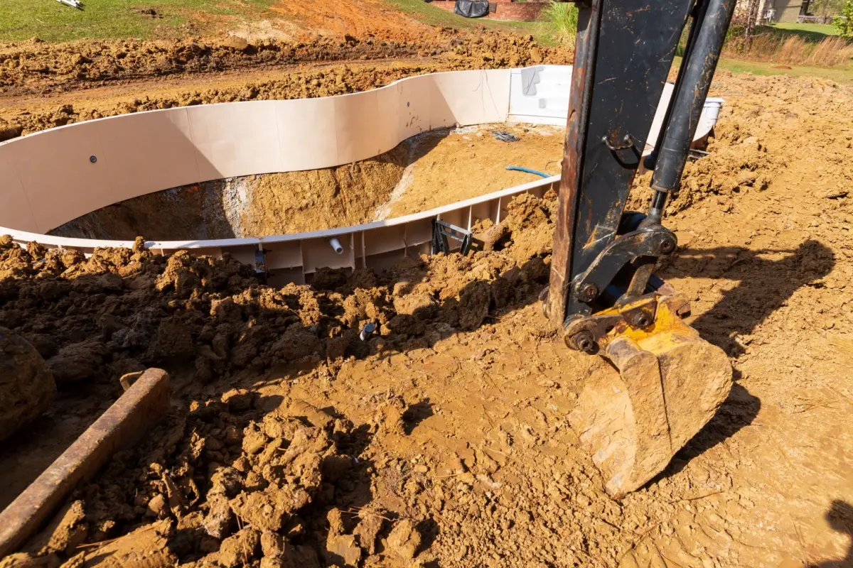 A pool being installed in a backyard.