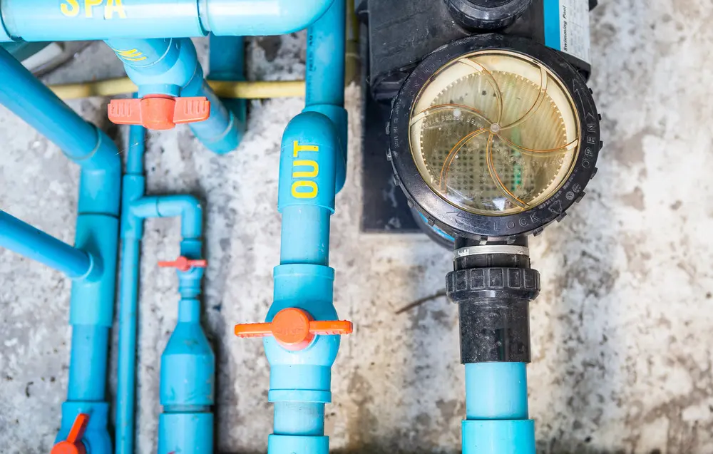 Swimming pool pump connected to spa lines, valves and PVC plumbing.