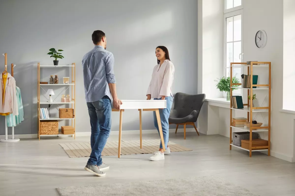 Couple moving a light, portable desk