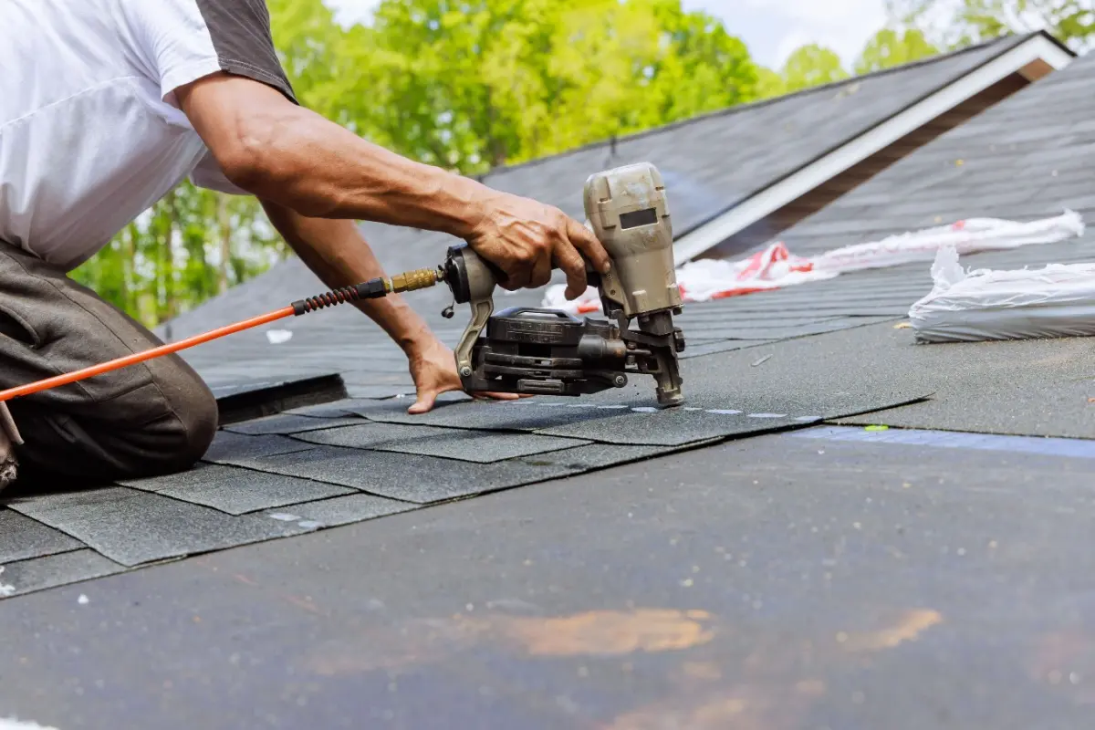 Roof contractor nailing in shingles.