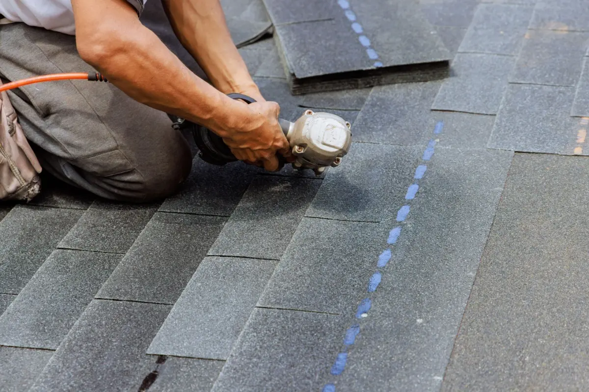 Man replacing shingles on a roof.