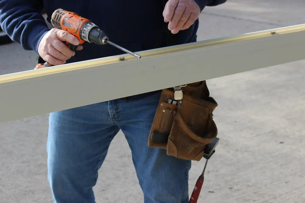 Contractor preparing an aluminum gutter section before installation